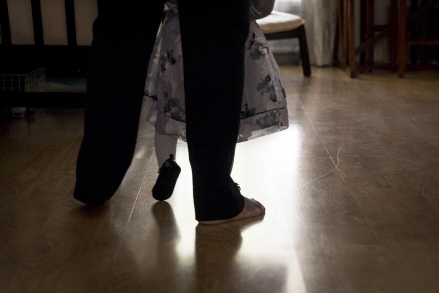 Wanda holds Soleil's hands as she learns to walk.