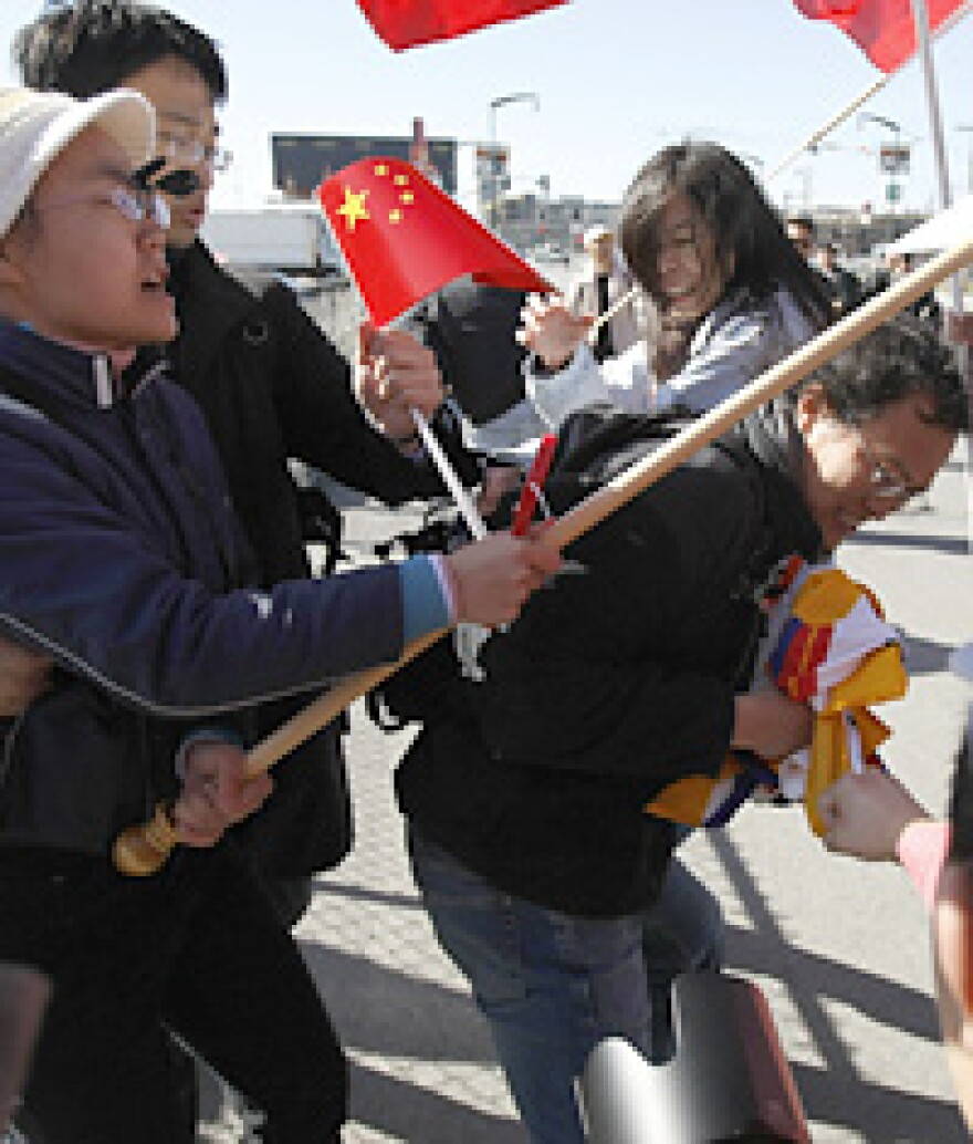 A man carrying a Tibetan flag is attacked by pro-China supporters awaiting the start of the Olympic torch relay on Wednesday in San Francisco.