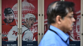 A pedestrian passes by a poster outside of the Capital One Arena on June 5, 2018 in Washington, D.C., as the Washington Capitals head into game 5 of the Stanley Cup against the Vegas Golden Knights. (Mandel Ngan/AFP/Getty Images)