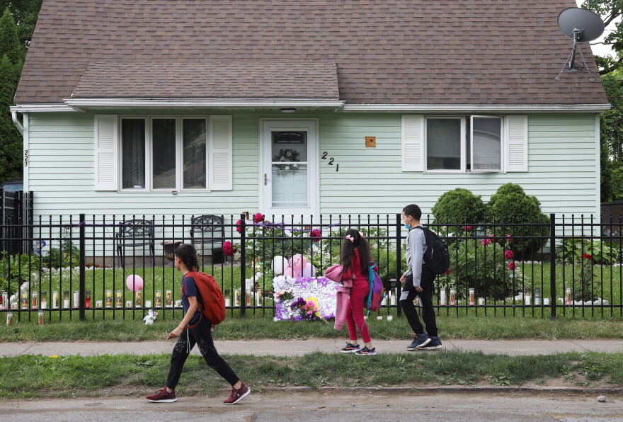 Children walk by the property where 16-year-old Zahira Smith was shot and killed.