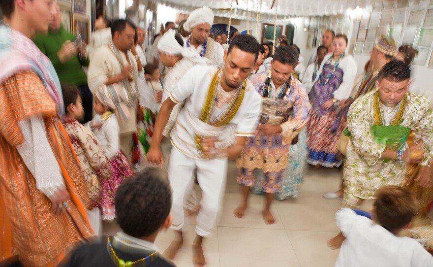 At a sacred festival day in Sao Paulo, men possessed by orixas — spirits of the gods — dance before getting dressed in orixas costume. They are participating in an Olubaje party, a Candomblé ritual for cleansing life of bad things and healing. The main god at this party is Omulu, or "the one with straws," the god of life and death who is known for healing diseases.