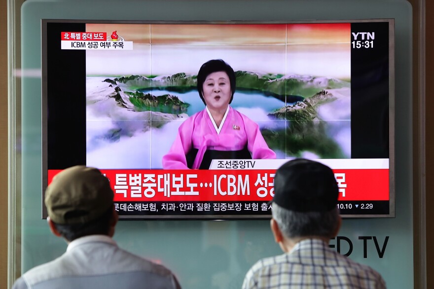 People watch North Korea's state-run television in 2017 as presenter Ri Chun Hee announces that North Korea has test-launched its first intercontinental ballistic missile.