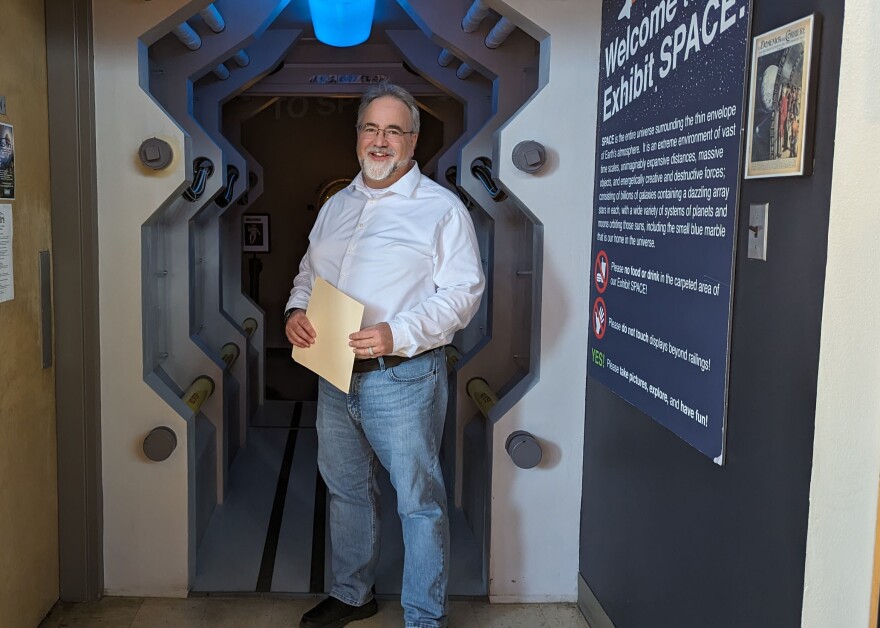 Paul McFarlane, the director of the Fleischmann Planetarium, stands in front of the SPACE exhibit at the planetarium.