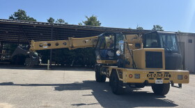 A large yellow construction vehicle with a man sitting inside.
