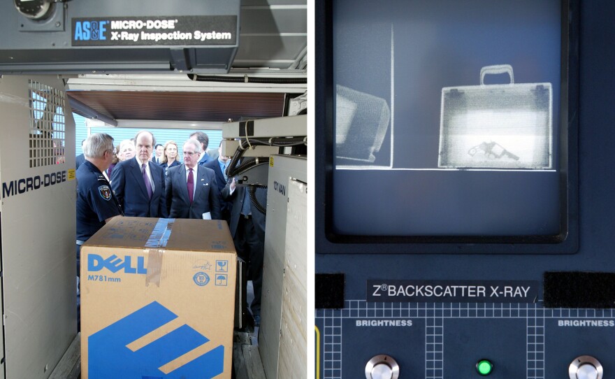 Jan. 24, 2002 at Port Everglades in Ft. Lauderdale, Fla. Customs inspector Lance Howard (left) demonstrates to Customs Commissioner Rob Bonner (center) Immigration and Naturalization Service Commissioner Jim Ziglar the operation of the American Science and Engineering Micro-Dose 101 X-ray machine. A handgun (right) inside a briefcase is displayed on the screen of the machine.