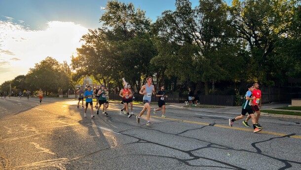 A group of marathoners and half-marathoners runs alongside a pacer — a runner running a predetermined pace — west on Douglas. The 2025 Prairie Fire Marathon route took runners through College Hill and back again.