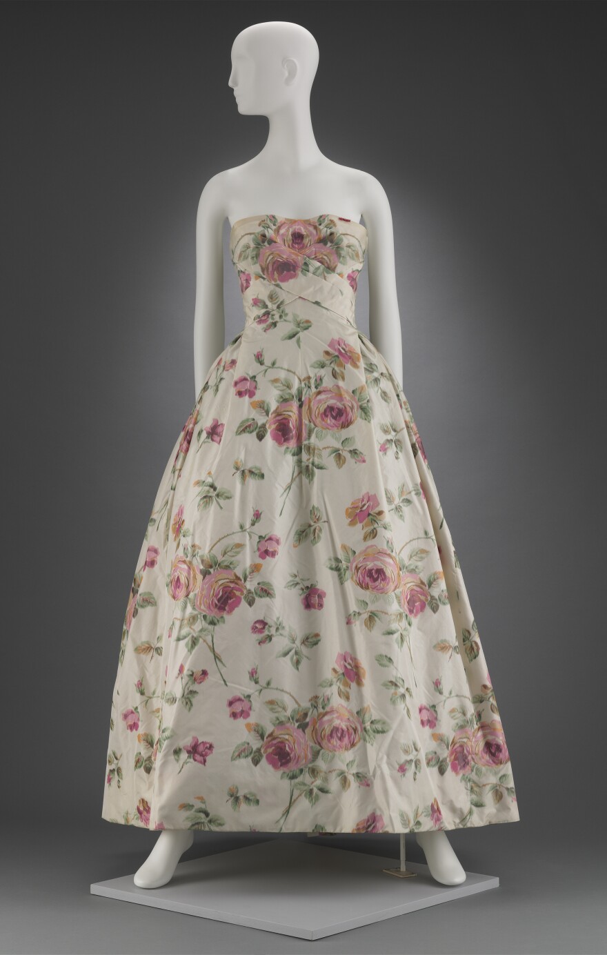 Big, pink flowers bloom on ivory silk in this 1956 dress by Christian Dior.