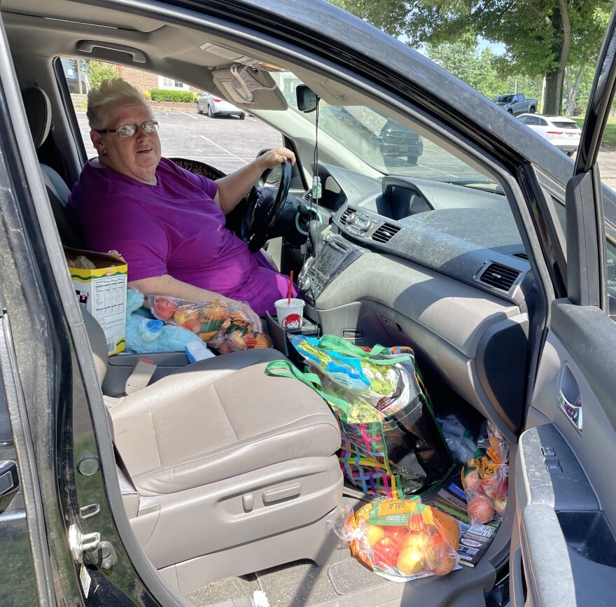 Ruth Cummings sits inside her minivan with produce she picked up from the local food pantry.