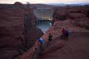 People view the Glen Canyon Dam from a viewpoint above the Colorado River, Tuesday, July 14, 2026, in Page, Ariz. (AP Photo/John Locher)