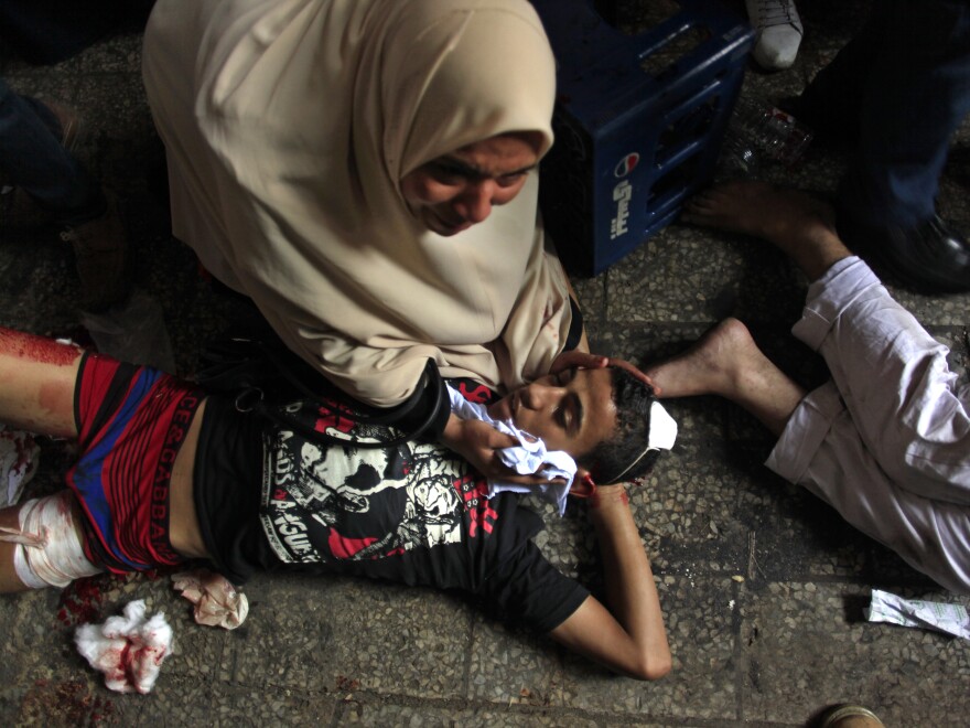 Egyptians lie on the ground after being injured during clashes between security forces and Morsi supporters in Ramses Square in Cairo on Friday.
