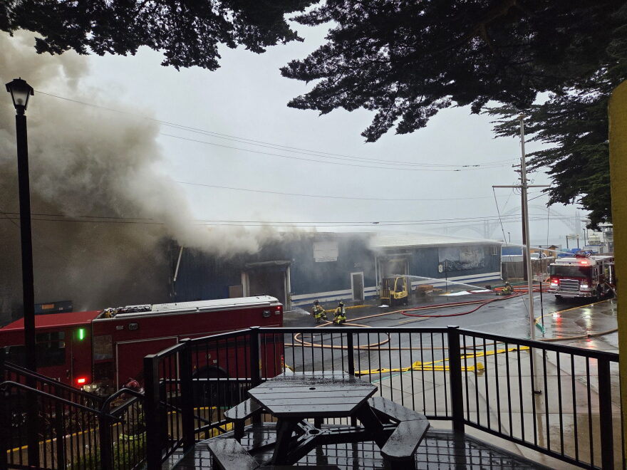 Firefighters pour water into the Pacific Seafood plant along SE Bay Boulevard in Newport Sunday morning after a fire broke out, releasing ammonia into the air and causing a partial roof collapse.