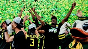 Basketball players celebrate in a rain of confetti