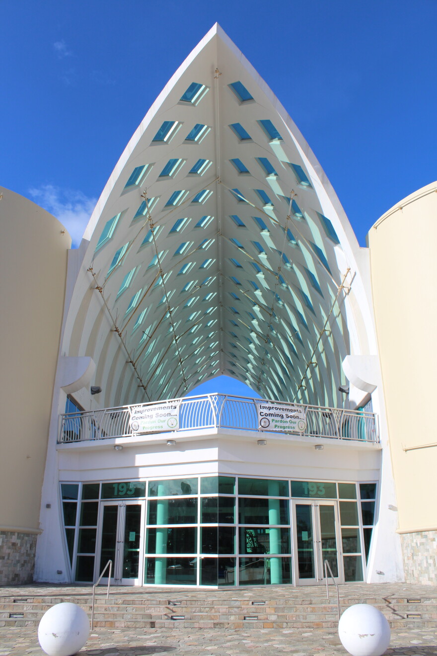 Entrance of the Guam Museum, located in Hagatna. The entrance is covered with glass windows, and a triangular white cement roof. 