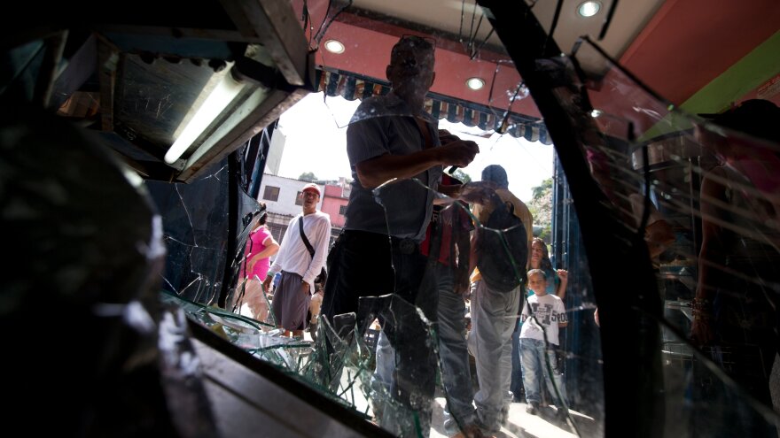 Customers enter a bakery in Caracas, Venezuela, on June 10, a day after it was looted.Bakeries and grocery stores are being ransacked in growing food-related violence in recent weeks.