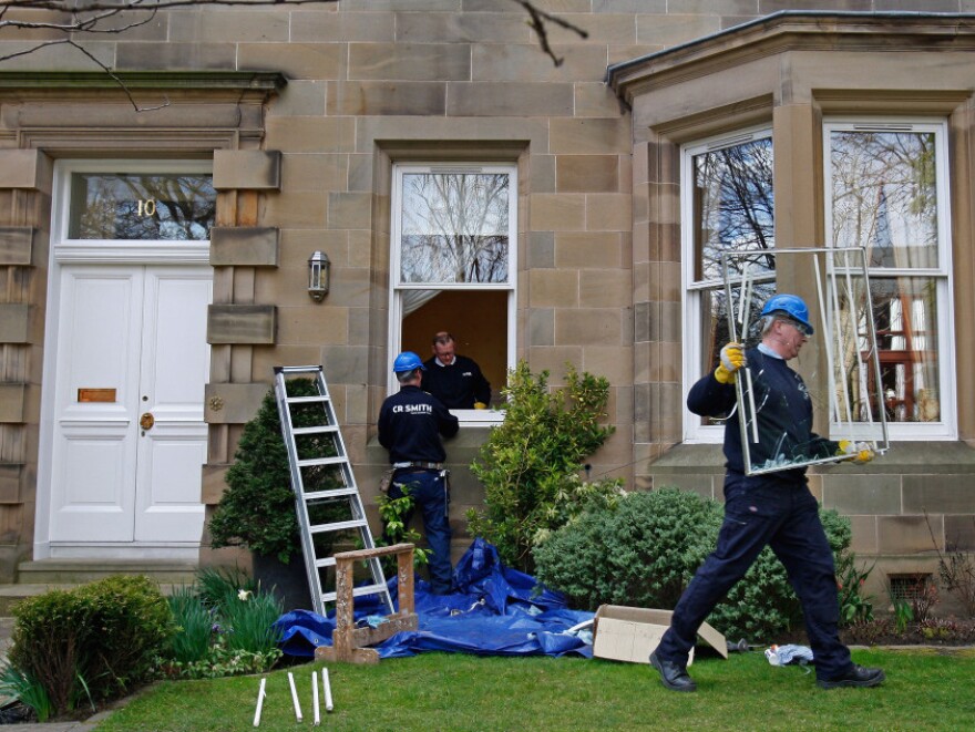 A glazier removes a smashed window at Goodwin's home  in Edinburgh, Scotland, after it was attack by vandals overnight on March 25, 2009. Public outrage ran high after the disgraced banker left his job with a pension of more than $1 million a year. Eventually, he agreed — reluctantly — to half that amount.