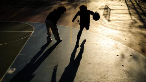 Young boys play basketball on a playground in the Hamilton Heights neighborhood of Manhattan in New York City on November 19, 2025. (Charly Triballeau/AFP via Getty Images)