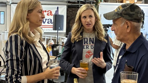 Congressional candidate Maura Sullivan talks with a voter as NJ Gov. Mikie Sherrill looks during a stop at To Share Brewing Company in Manchester