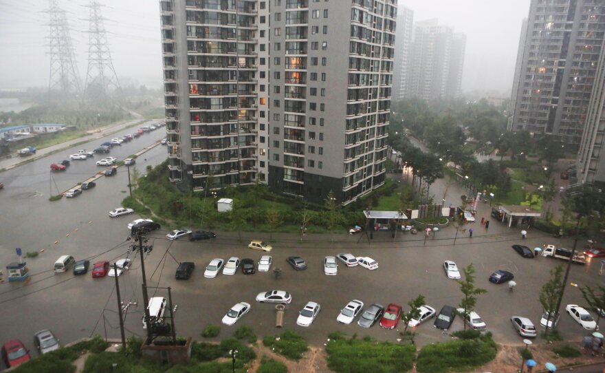 Cars are submerged in floodwaters around a residential block in Beijing.