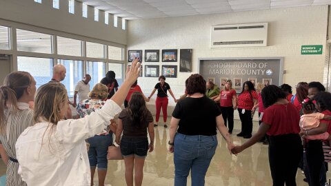 Students, teachers and parents from Wyomina Park Elementary held hands in prayer before the School Board meeting.