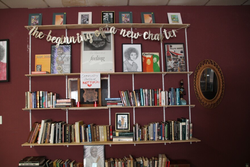 Books are lined up along wood shelves.