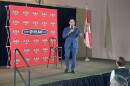 Man speaking into a microphone on a stage
