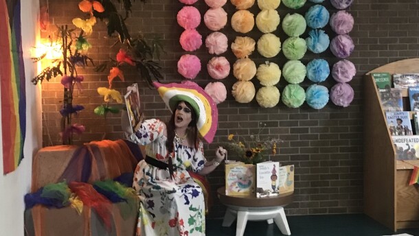 Miss Ginger Devine, a drag performer, reads from a children's book.