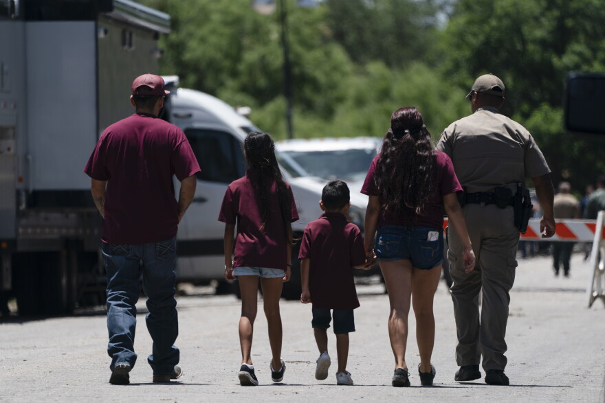 A state trooper escorts a group of family onto the campus of Robb Elementary School in Uvalde, Texas, Wednesday, May 25, 2022. Desperation turned to heart-wrenching sorrow for families of grade schoolers killed after an 18-year-old gunman barricaded himself in their Texas classroom and began shooting, killing at least 19 fourth-graders and their two teachers.