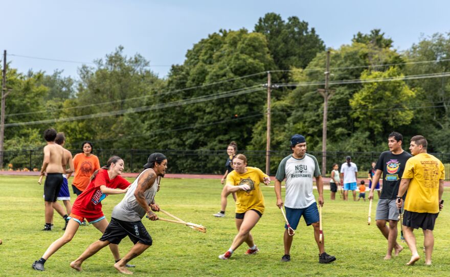 Stickball players chasing one another at Cherokee National Holiday