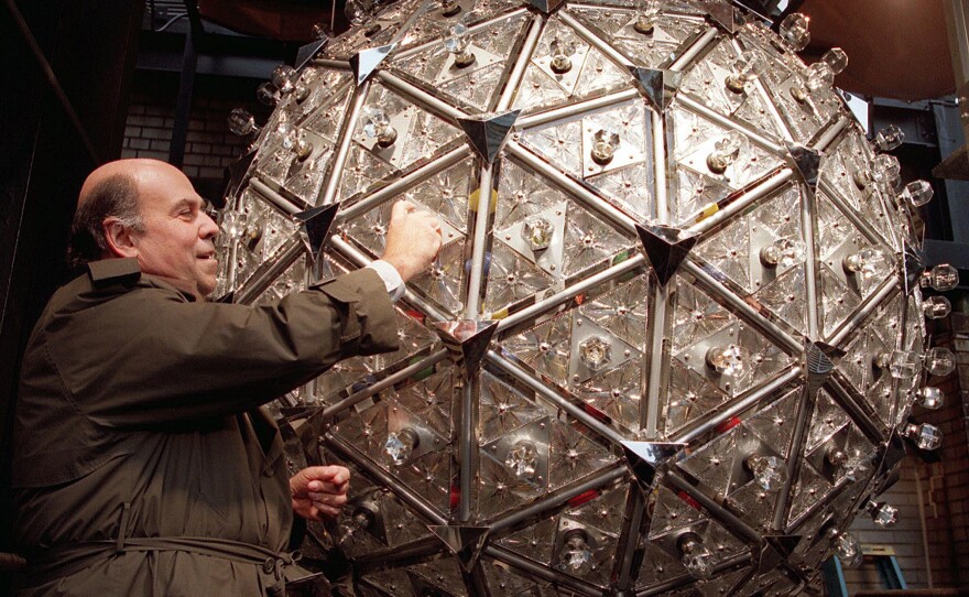 Steven Goldmacher of Philips Lighting Co. screws in a light bulb, Dec. 20, 1999. The 1,070-pound crystal ball, 6 feet in diameter, made its debut at the millennial celebration.