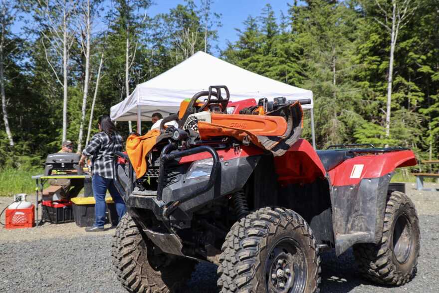 A chainsaw rests on an ATV 