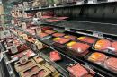 Packages of ground beef, beef patties and steaks line grocery store shelf
