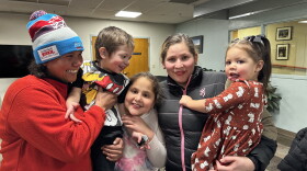 Libia Guzmán, left, beams while watching her newfound family pose for a photo on Nov. 27, 2023 at Carbondale’s Third Street Center. Guzmán is part of a group of over 100 migrants, mostly from Venezuela, who recently arrived in the Roaring Fork Valley.