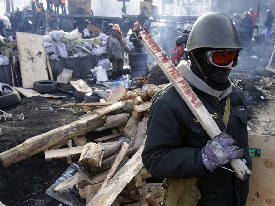 A protester guards a barricade in Kiev, Ukraine, on Monday.