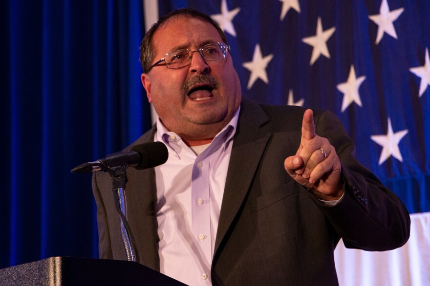 Man points finger from podium