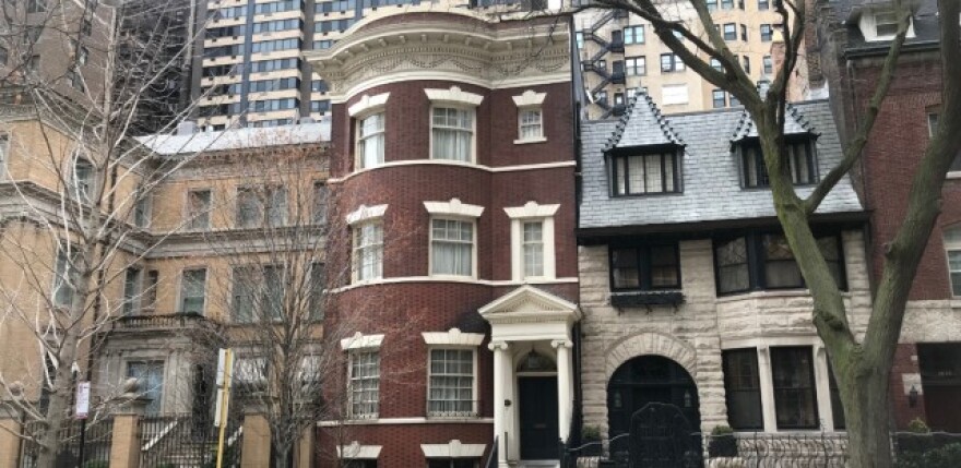 Illinois Gov. JB Pritzker and his wife, First Lady MK Pritzker, purchased a tan mansion (left) and red brick home (center) more than a decade ago in Chicago's upscale Gold Coast neighborhood. WBEZ has learned the federal government is investigating the Pr