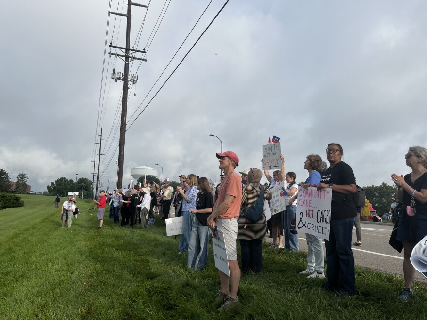 People clap and chant "immigrants are welcome here" as a Haitian migrant walks into his appointment at the Blue Ash ICE office Sunday. Haitian immigrants began receiving letters summoning them to appear for meetings with ICE officials in late July, days after Temporary Protected Status ended.