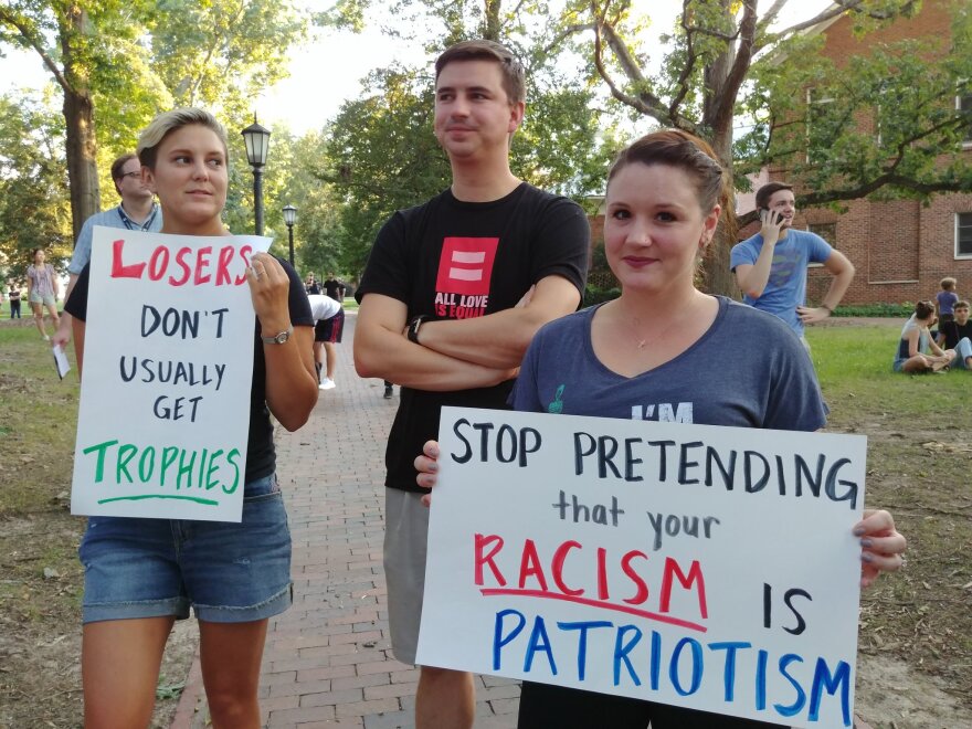 University of North Carolina alumni hold handmade signs at a rally in protest of the Silent Sam statue at the University of North Carolina in Chapel Hill on Tuesday, August 22, 2017.