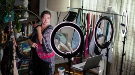 Nichole MacDonald, founder and creator of the Sash bag, showcases her merchandise while livestreaming a sale from her home in San Diego on April 23, 2026. MacDonald says her small business is being severely affected by the rise of tariff costs and fuel prices due to the war in Iran.