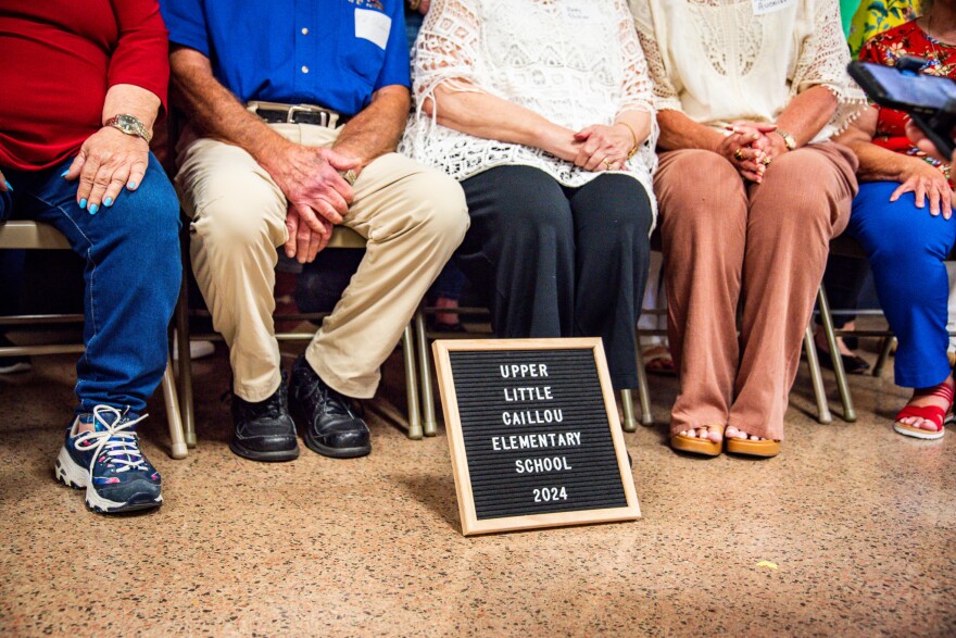 Former educators and students at Upper Little Caillou Elementary School pose for a group photo with a plaque during the Chauvin Schools Reconnect reunion on Saturday, April 27, 2024.