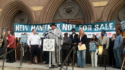Pastor Scott Marks, Director of New Haven Rising at the microphone as he joined with local organizers and tenants during a press conference October 20, 2026 outside the New Haven City Hall to ban short-term rentals in an effort to protect New Haven's housing market.