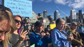 People gathered to listen to the announcement about the latest orca death brought signs calling for the breaching of the Snake River dams.