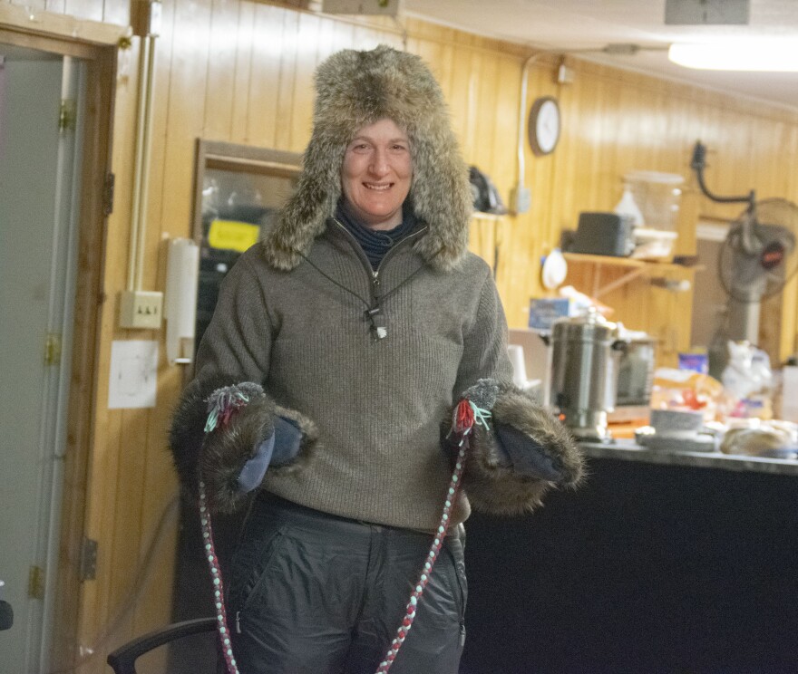Yukon Quest frontrunner Josi Shelley holds up beaver mittens gifted to her by Fort Yukon resident Corrima Cadzow and Louie Fairchild on Feb. 10, 2026. (Shelby Herbert/KUAC)