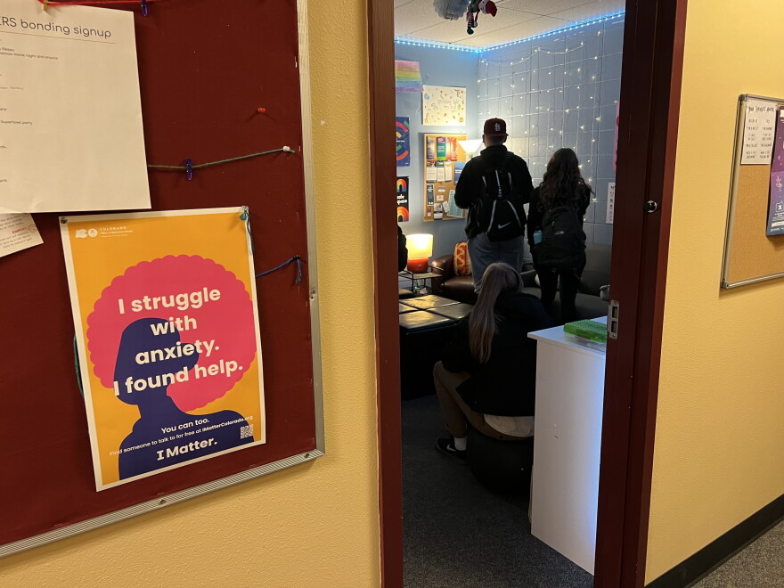 Peer counselors stand in a room outside a hallway