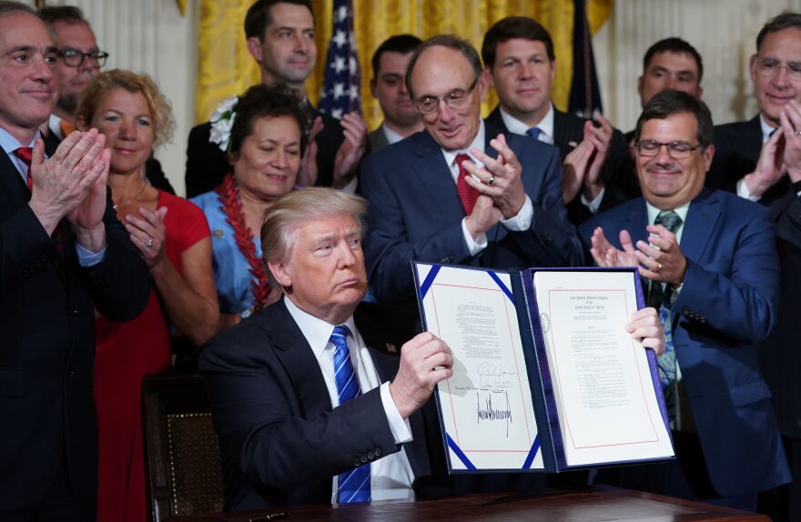 President Trump holds up the signed Department of Veterans Affairs Accountability and Whistleblower Protection Act of 2017 on Friday.