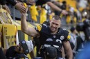 A man in a football uniform high-fives the crowd.