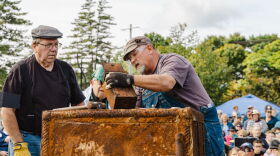Three men look inside of the a rusted metal box that was removed from a thousand-pound, century-old, safe. 