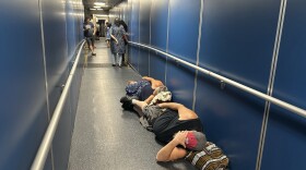 Travelers at Los Angeles International Airport sleep in a jetway for a delayed United Airlines flight to Dulles International Airport due to a widespread global outage early Friday, July 19, 2024, in Los Angeles.