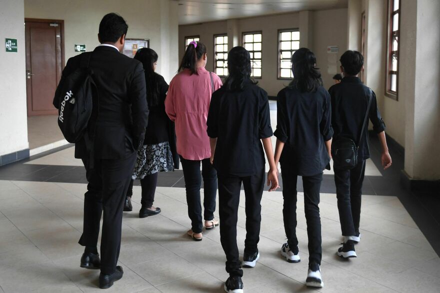 Loh Siew Hong, in a pink shirt, arrives with her three children at Kuala Lumpur High Court for a hearing on May 11.