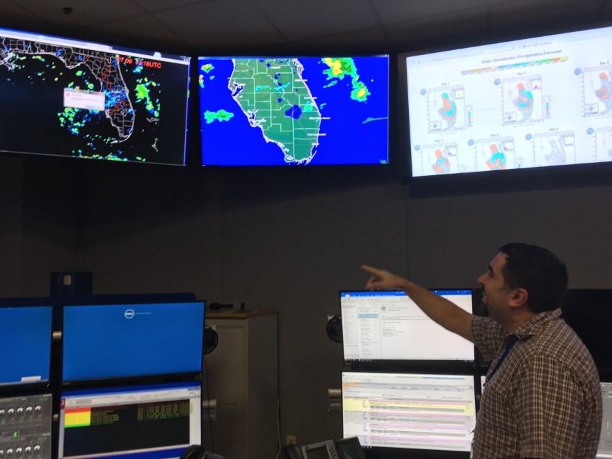 SFWMD operations control specialist Ariosto Munoz alters the flow of water from a control room in the West Palm Beach headquarters.
