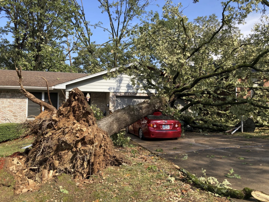 An uprooted tree damages a home and a car in a Little Rock neighborhood on Wednesday, Sept. 6, 2023, following a severe storm. The storm hit neighborhoods that a tornado tore through last spring, damaging some of the homes rebuilding from that tornado.